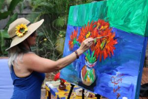 Caroline Karp Artist painting red daisies