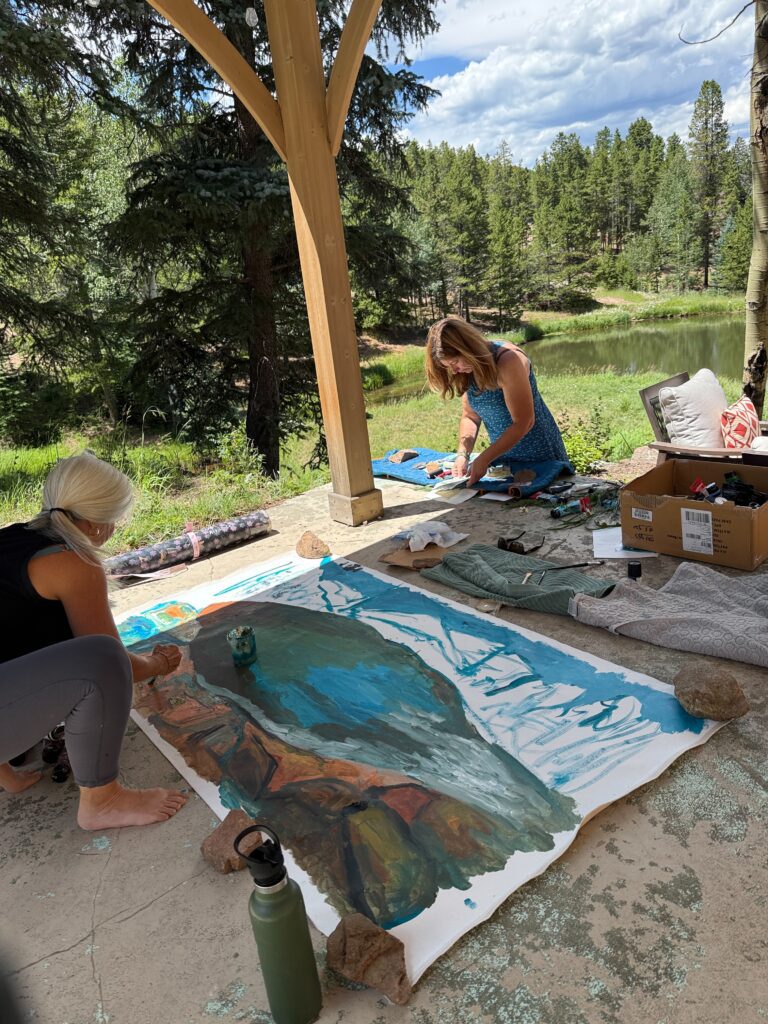 two artists painting at a retreat in Colorado by a lake.